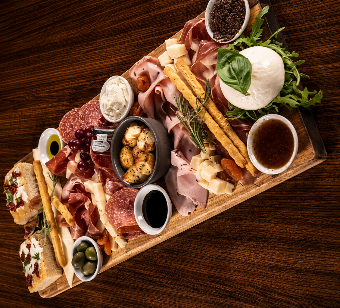 Veeno Italian sharing board with cured meats, mozzarella, olives and breadsticks — overhead view